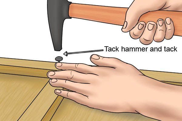 Tack hammer finishing off a tack that has been placed by a push pin 
