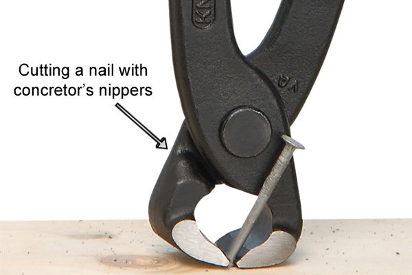 Cutting a nail with concretor's nipping pliers