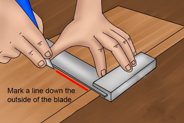 Using a marking knife to mark a line down the outside of an engineer's square blade