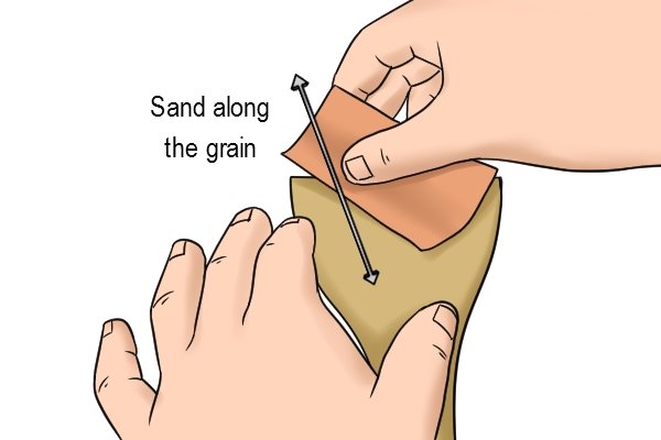 Use a fine to medium grade sandpaper and sand along the grain of the wood.