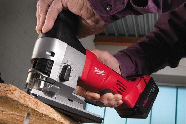 Barrel grip jigsaw being used to cut wood with two hands