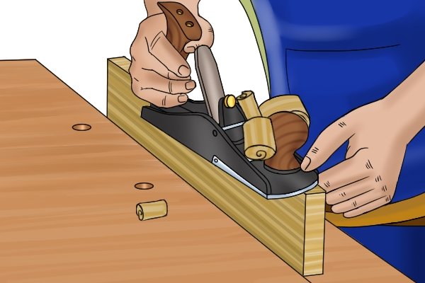 Planing the edge of a piece of wood with a scrub plane