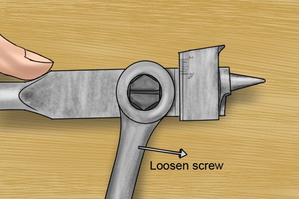 A DIYer using a hexagonal socket wrench to loosen the adjuster screw on an expansive bit