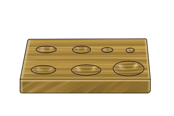 Round-bottomed holes that have been drilled into a wooden workpiece using a spoon bit