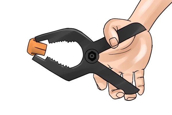 Open the jaws by pushing the handles together
