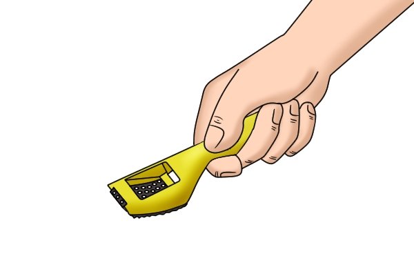 The first step is to grip the handle of the surform shaver