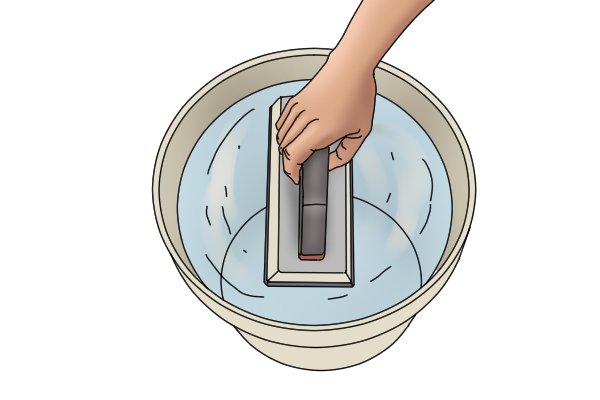 Dipping rubber float into bucket of water