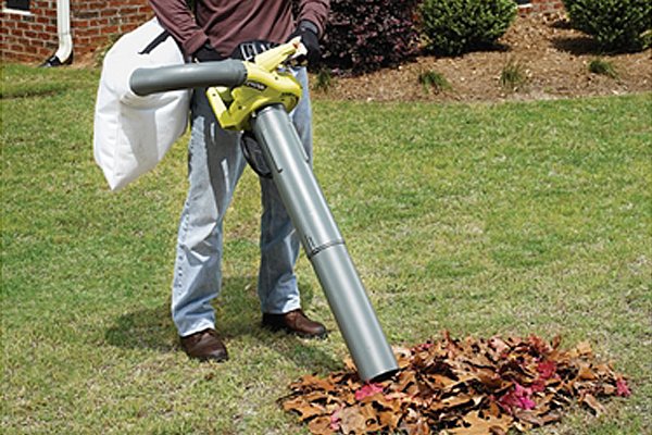 Petrol blower vacuum sucking up leaves