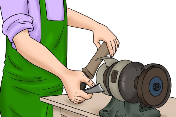 Image showing how to sharpen an inside bevelled adze by bracing the handle against the grinder's safety guard