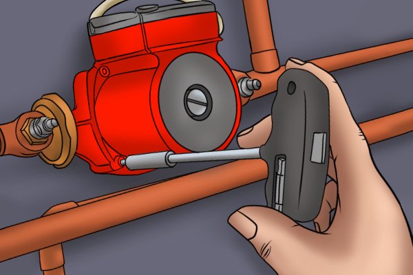 Image of a DIYer using a boiler pump multitool to loosen the retainer bolts on a boiler pump head