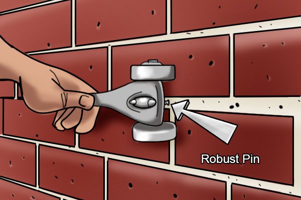 You hold the tool parallel to the mortar you wish to rake. Use your thumb and fingers to push and drag the robust pin along these areas of mortar. As you drag the pin through the mortar use your weight to push the brick rake down into the mortar. 