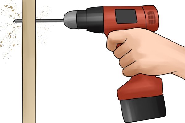 Red cordless drill driver drilling a hole with the user holding it with two hands