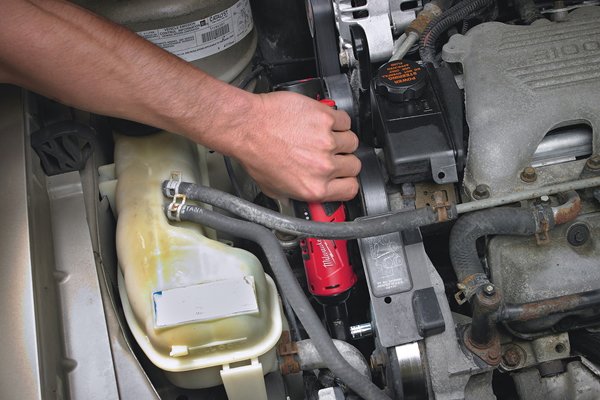 Using a right-angled cordless impact driver in an engine