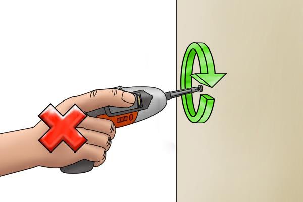 Cordless screwdriver being used with arrows to show chuck turning