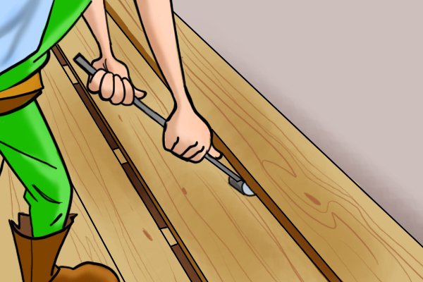 Using a flooring chisel to lift floorboards
