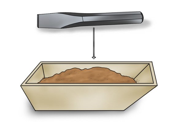 A cold chisel (left) and box of sand (right)