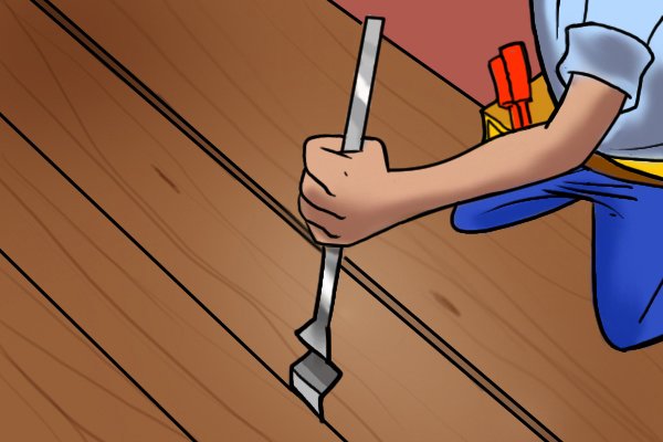 Using a flooring chisel to lift floorboards