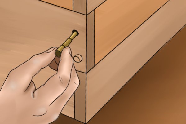 DIYer inserting dowels into a pre-drilled workpiece