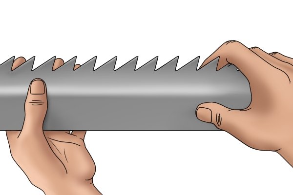 Image of a DIYer showing a taper saw file that fits between a saw's teeth and is therefore able to be used for sharpening