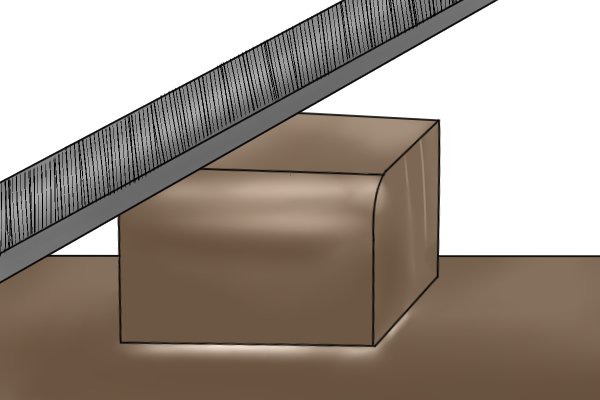 Image of a DIYer using a flat file to round off the corner of a metal work piece