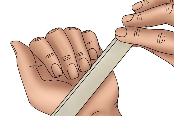 Image showing a DIYer using a hand file to file their nails, taking advantage of the safe edge to rest against their finger