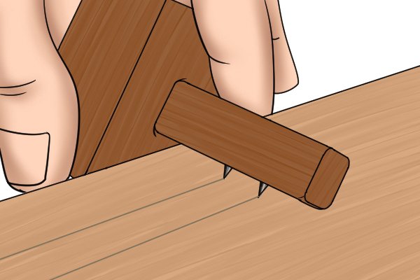 A mortise gauge marking two lines on a piece of wood so a mortise can be cut out