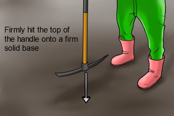 Securing the pickaxe head in place on the handle, firmly hit the top of the handle onto a firm solid base