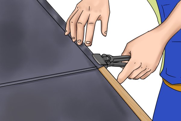 Seaming pliers in use on a roof