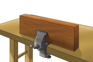 Clamp of a vice around wood.