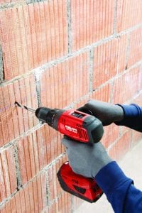 Hilti SF 6H-A22 Cordless Hammer Drill Driver 3 drilling through a brick wall by a masonry worker