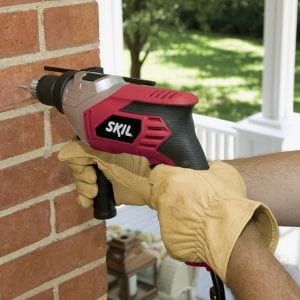 Hammer Drill drilling through a brick hall