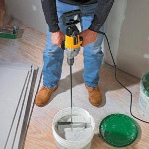 Mixing plaster with Dewalt mixer drill.