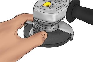 Releasing a clamping lock on angle grinder.
