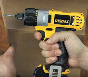Squeezing trigger on Dewalt cordless screwdriver.